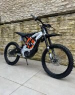 A sleek white phantom Sur-Ron LBX 2023 electric dirt bike on display.